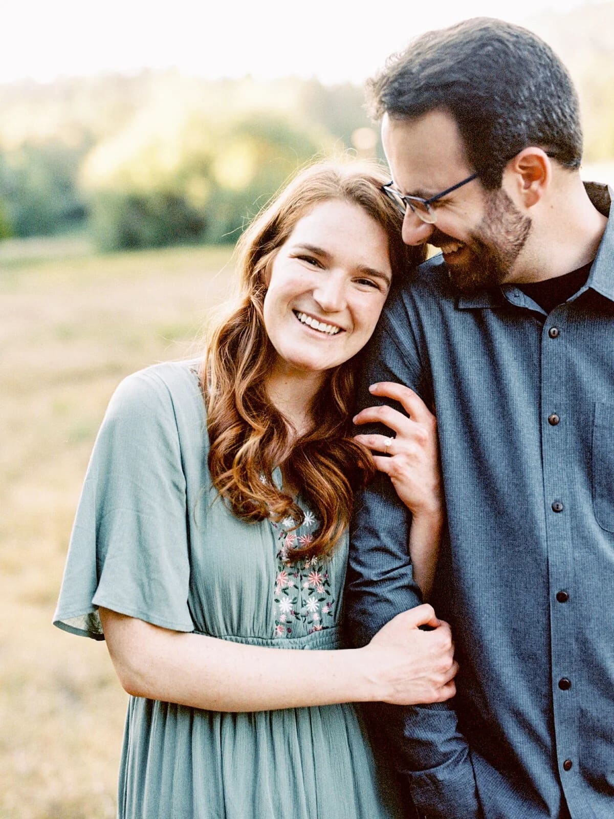An engaged couple in a mountain meadow at golden hour.